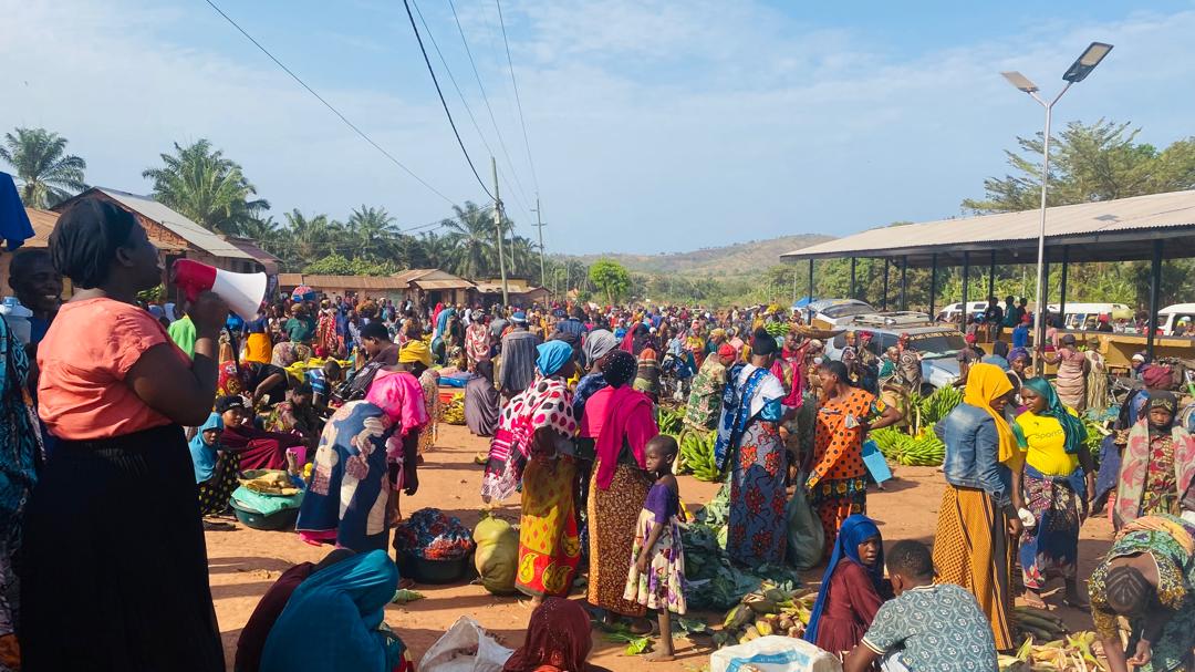 Women and families gather at a community market in Tanzania.